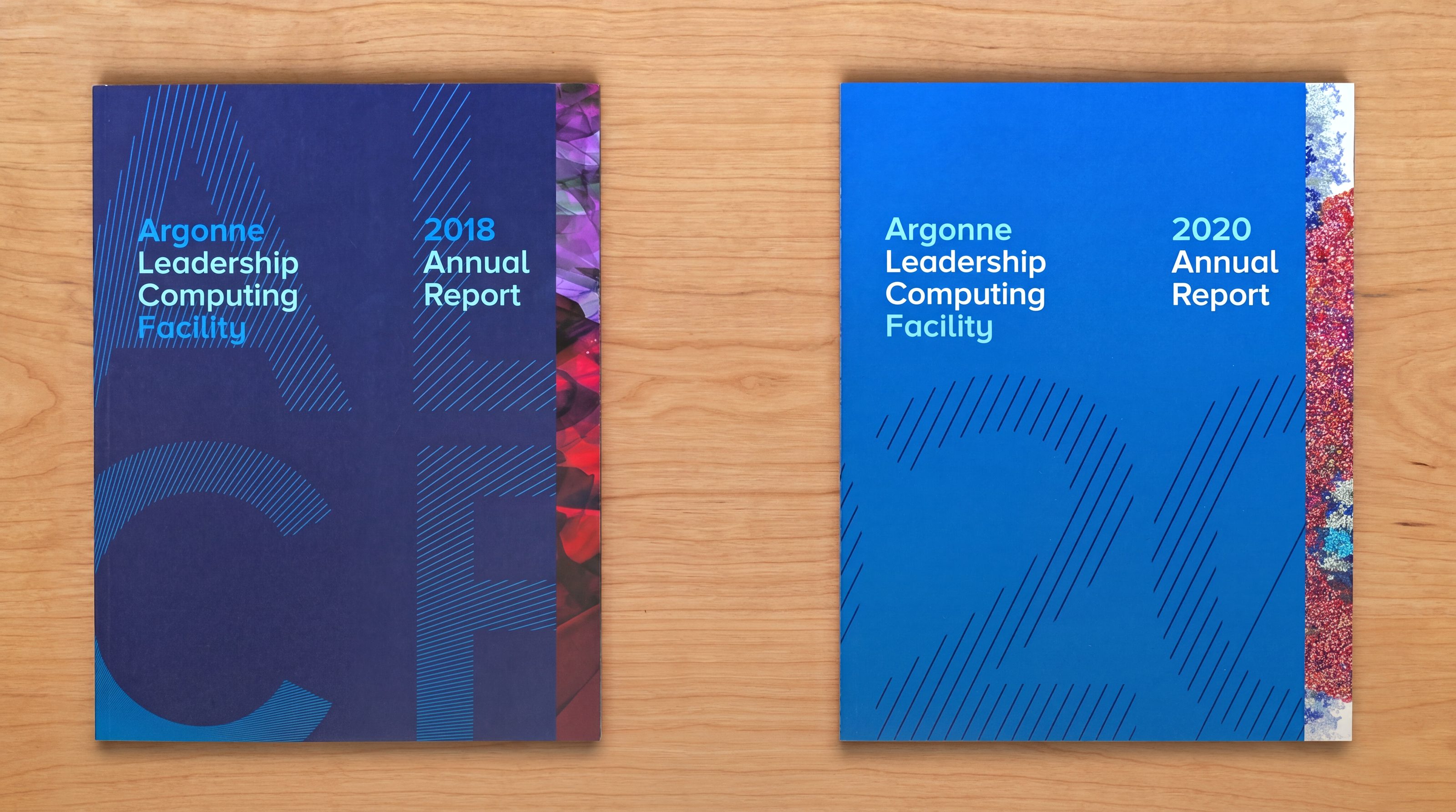 Two printed ALCF Annual Reports side by side on a wood table: 2018 in dark navy with the ALCF letterforms drawn in diagonal rules, 2020 in bright blue with the year drawn the same way, each with a strip of scientific visualisation down its outer edge.